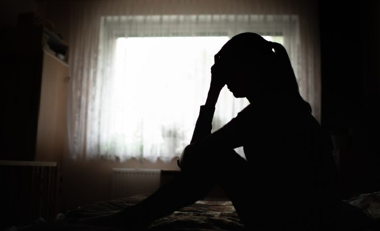 Grieving woman sitting on bed